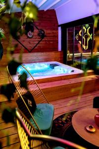 a jacuzzi tub with a chair and a table at Sxcape ROOM in Aigues-Mortes