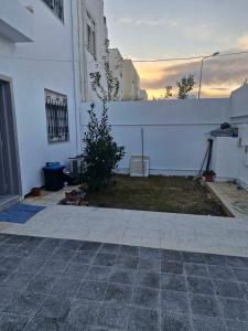 a white building with a fence and a yard at Villa résidence privé Ariana in Ariana