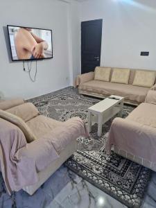 a living room with a couch and a tv on the wall at Villa résidence privé Ariana in Ariana