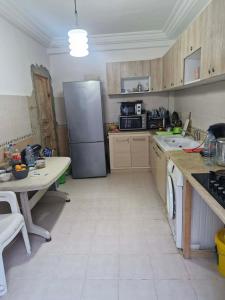 a kitchen with a refrigerator and a table in it at Villa résidence privé Ariana in Ariana