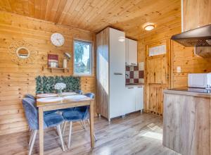 a kitchen and dining room with a table and chairs at Domki parterowe ANITA in Zawóz +18 photos