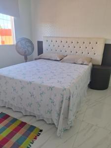 a bedroom with a large bed with a white comforter at Lar Doce Lar in Itabira