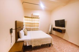 a hotel room with a bed and a tv at Reforma 516 in Oaxaca City