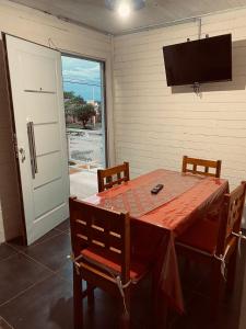 a dining room with a table and chairs and a television at Cabaña Valle de Montañas in Tinogasta