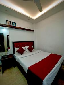 a bedroom with a large bed with red and white sheets at Hotel Parth Palace in New Delhi