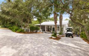 a house with a palm tree in front of a driveway at Three Sisters Bungalow in Santa Rosa Beach