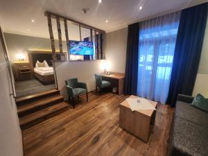 a living room with a couch and a bed and a television at Hotel Seeblick in Bad Reichenhall