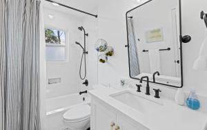 a white bathroom with a shower and a sink at Three Sisters Bungalow in Santa Rosa Beach +42 photos