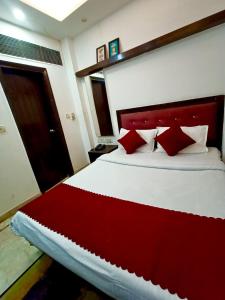a bedroom with a large bed with red pillows at Hotel Parth Palace in New Delhi