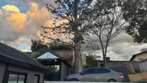 a car parked in front of a house with a tree at Tiny House Socorro in Socorro