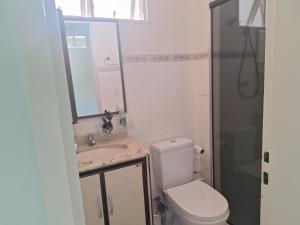 a bathroom with a toilet and a sink and a mirror at Lar Doce Lar in Itabira