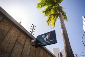 a sign on the side of a building with a palm tree at Pousada e hostel Italia in São Luís