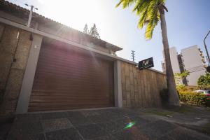 a garage door with a palm tree next to a building at Pousada e hostel Italia in São Luís +48 photos