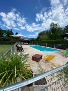 a swimming pool with two chairs and an umbrella at LA TORRE - Complejo de cabañas in Villa Rumipal