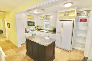 a kitchen with white cabinets and a refrigerator at Pelican Cottage in Jensen Beach +20 photos