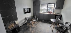 a kitchen with two tables and chairs and a fireplace at Barnhous in Mykulychyn