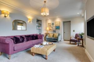 a living room with a purple couch and a table at 4 Bed in Newlyn oc-abcorc in Newlyn