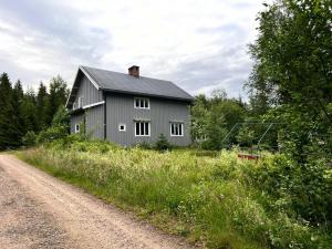 a gray house on the side of a dirt road at Urlaub im Elchland in Letafors