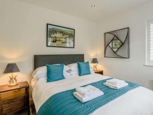 a bedroom with a large bed with blue pillows at 4 Bed in Hope Valley oc-89431 in Bradwell
