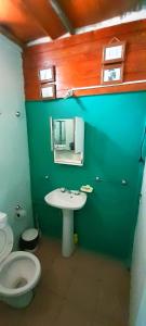 a bathroom with a white toilet and a sink at Dpto en Santa María de Punilla in Córdoba