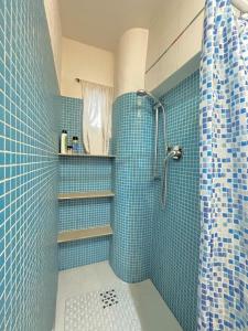 a blue tiled bathroom with a shower and a sink at Caterina Biennale Apartment in Venice +19 photos