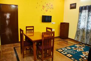 a dining room with a wooden table and chairs at Srinivasam service apartment in Madurai