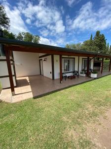 a house with a patio and a grass field at LA TORRE - Complejo de cabañas in Villa Rumipal