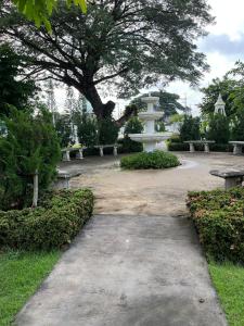 a park with a fountain and benches and a tree at Wilfrid villa in Hua Hin