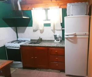 a small kitchen with a refrigerator and a stove at Dpto en Santa María de Punilla in Córdoba