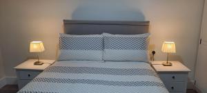 a bedroom with a bed with two lamps on tables at Doolin Farm Apartment in Doolin