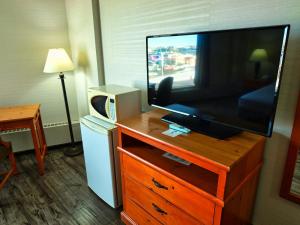 a flat screen tv on a dresser in a hotel room at Continental Inn & Suites in Edmonton