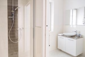 a white bathroom with a shower and a sink at Domus Residence in Domodossola +28 photos