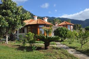 una casa en un campo con árboles delante en Finca Madrugada, en Santa Cruz de la Palma