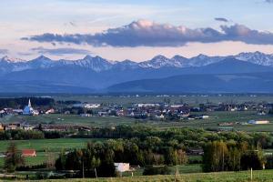 a town in a field with mountains in the background at Chatki ŁoRawa w Jabłonce in Jabłonka