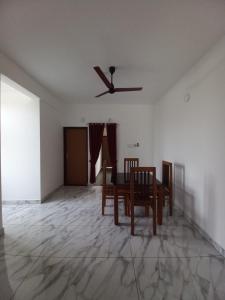 a dining room with a ceiling fan and a table and chairs at Enpathil Residency in Kollam