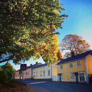 una fila de casas en una calle con un árbol en Lingonberry Cottage en Tammisaari