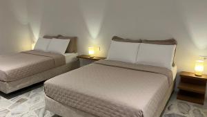a hotel room with two beds and two lamps at Casa Celisa in Cali