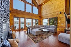 a large living room with a couch and a tv at Constellations Lake House at Chelan - Pacific Retreats in Chelan