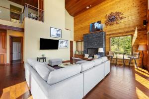 a living room with a large couch and a fireplace at Constellations Lake House at Chelan - Pacific Retreats in Chelan