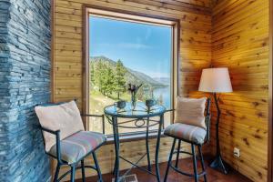 a balcony with a table and two chairs and a large window at Constellations Lake House at Chelan - Pacific Retreats in Chelan +38 photos