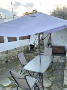 a table and chairs under an umbrella on a patio at Apartamento El Olivar de Cáceres in Cáceres