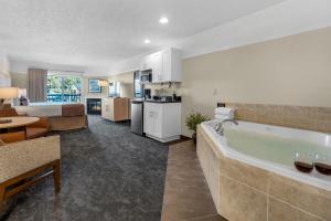 a living room and kitchen with a tub in a room at Looking Glass Inn in Lincoln City +26 photos