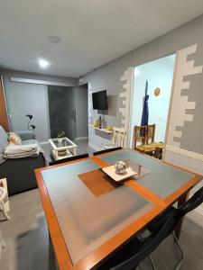 a living room with a table and a room with a bed at Apartamento El Olivar de Cáceres in Cáceres