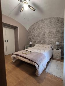a bedroom with a large bed and a brick wall at Apartamento El Olivar de Cáceres in Cáceres +30 photos
