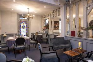 a restaurant with tables and chairs and a stained glass window at Logis Hôtels Restaurant Les 3 Rois in Issoudun