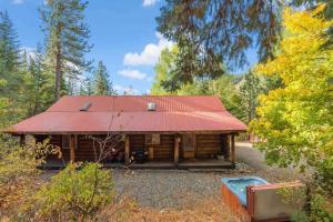 a log cabin with a red roof in the woods at Bear Ridge Cabin - Pacific Retreats in Leavenworth