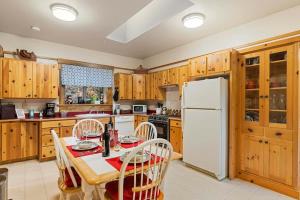 a kitchen with a table and a white refrigerator at Bear Ridge Cabin - Pacific Retreats in Leavenworth +25 photos