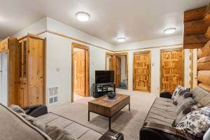 a living room with a couch and a tv at Bear Ridge Cabin - Pacific Retreats in Leavenworth