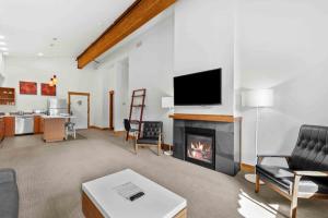 a living room with a fireplace and a flat screen tv at Front Street Suites - Pacific Retreats in Leavenworth