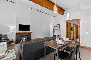 a living room with a couch and a table and a fireplace at Front Street Suites - Pacific Retreats in Leavenworth